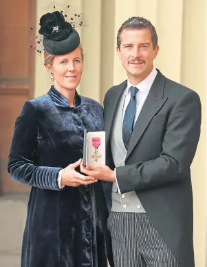  ??  ?? PROUD MOMENT: Bear Grylls and wife Shara with his OBE at Buckingham Palace