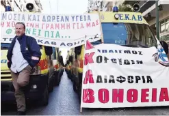  ??  ?? ATHENS: A rescuer stands in front of parked ambulances outside the Health Ministry in Athens yesterday during an anti-austerity protest, to demand funds to address deficienci­es and gaps in the health system. The banners read ‘national free health...