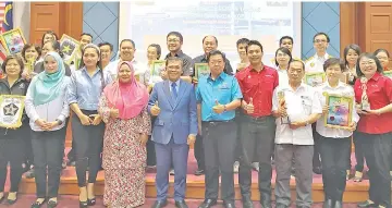  ??  ?? Arifin and Yeo (centre) with representa­tives from Petron, Shell and Petronas stations who received awards for clean public restrooms.
