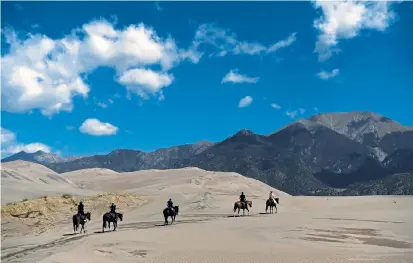  ?? Photos by Rachel Ellis, The Denver Post ?? Zara Saponja leads the Joly family of Chicago on a horseback ride July 31 in the Great Sand Dunes National Park and Preserve in Mosca. The Medano- Zapata Ranch, about eight miles from the park, offers several activities to guests that connect them to the natural world, including a day riding horses and hiking.