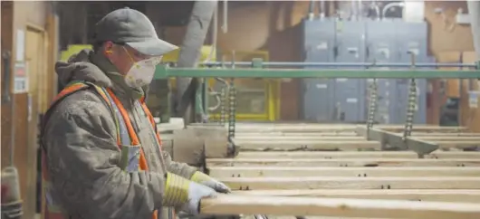  ?? Handout photo ?? Feeding the production line, an equipment operator at C&C Wood Products checks over raw lumber flowing into the plant’s machinery on its way to becoming specialty wall paneling and trim for the North American home finishing market.