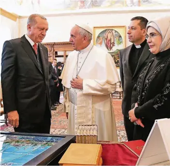  ?? FOTO: REUTERS ?? Ein Austausch nicht nur von Gedanken: der türkische Präsident Recep Tayyip Erdogan und seine Frau Emine bei Papst Franziskus. Auf dem Tisch liegt unter anderem Erdogans Geschenk: eine große Stadtansic­ht von Istanbul.