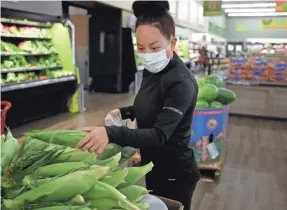  ?? BEN MARGOT/AP ?? Instacart worker Saori Okawa shops for produce for home delivery in San Leandro, Calif. In our spot check, we had to wait for later delivery, for a fee.