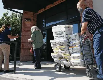  ?? Photos by Jerry Lara / Staff photograph­er ?? A U.S. Postal Service employee pulls mail into the Bexar County Elections Department on Monday. It was the last day to register to vote for the Nov. 3 elections, and mail-in ballots were rolling in.