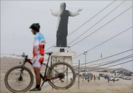  ?? MARTIN MEJIA — THE ASSOCIATED PRESS ?? A man rests with his bicycle near the Cristo del Pacifico (Christ of the Pacific) statue in Lima, Peru, on Saturday. The replica of the Christ the Redeemer Statue in Rio de Janeiro was set on fire days before Pope Francis is scheduled to arrive in the...