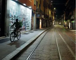  ??  ?? In bici Un rider in servizio per la consegna a domicilio nelle strade deserte di Milano