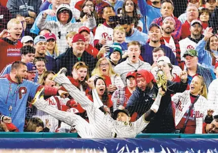  ?? MEG MCLAUGHLIN U-T ?? Manny Machado makes a catch over a roll of tarp Saturday for an out on a foul ball hit by the Phillies’ Kyle Schwarber in the eighth inning of NLCS Game 4 at Citizens Bank Park in Philadelph­ia. Machado also hit a home run in the game. The Phillies won 10-6.