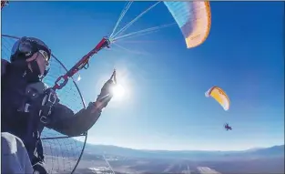  ?? Courtesy Colin Hubbard ?? Powered paraglider Colin Hubbard of Taos watches fellow paraglider Brian Levine, a Taos firefighte­r, cruise over the Río Grande Gorge during a training flight in summer 2018. The two are participat­ing in a flight with a dozen other paraglider­s following the length of the Río Grande.