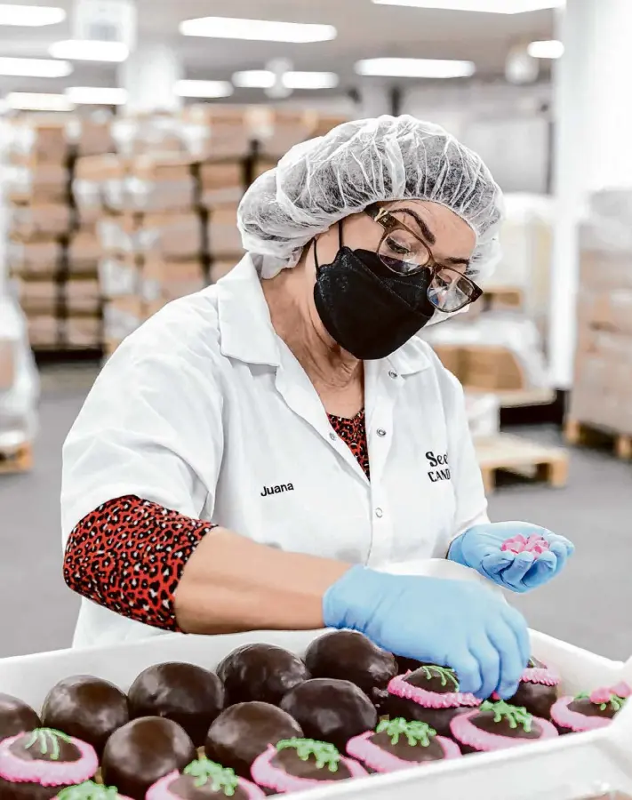  ?? Photos by Jessica Christian/The Chronicle ?? Juana Tostado decorates chocolate pecan butter Easter eggs at the See’s Candies factory in South San Francisco. See’s popular large eggs are all decorated by hand.