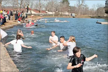  ??  ?? ABOVE: Paige Eubanks, right, and more than 40 other hardy souls take the Cave Spring Polar Plunge on New Year’s Day in Rolater Lake when the air temperatur­e hovered around 23 degrees. Some stayed in longer than others.