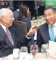  ??  ?? General Colin Powell (left) and Prime Minister Andrew Holness enjoying light conversati­on.