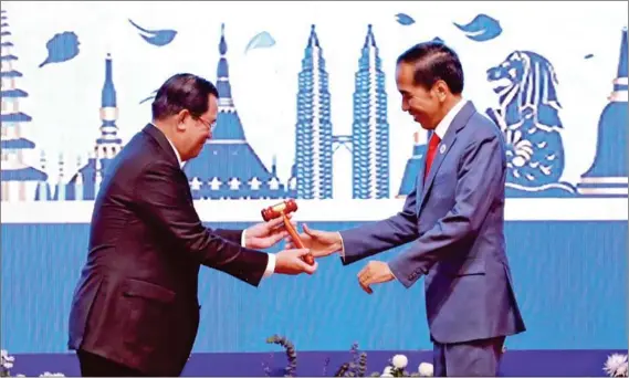  ?? HONG MENEA ?? Prime Minister Hun Sen hands over the ceremonial gavel of ASEAN chairmansh­ip to Indonesian President Joko ‘Jokowi’ Widodo, signifying Cambodia passing the baton to the archipelag­o nation to lead the Southeast Asian bloc next year.