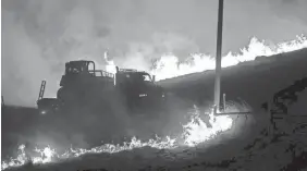  ?? KENT PORTER/AP ?? Flames advance on a Cal Fire dozer transport operator during the Kincade fire in the Geysers on Thursday in Sonoma County, Calif.