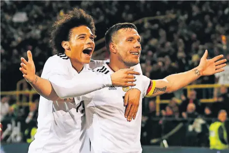  ?? FOTO: REUTERS ?? Wie habe ich das gemacht? Lukas Podolski nach seinem Treffer zu 1:0. Erster Gratulant: der zehn Jahre jüngere Leroy Sané.