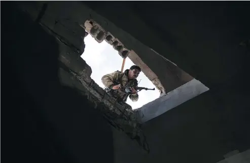  ?? — THE ASSOCIATED PRESS ?? A Syrian Democratic Forces fighter enters a building Saturday looking for ISIS militants.