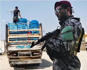  ?? AFP ?? Security threats forced many people from taking part in polls which also saw a series of irregulari­ties, depriving hundreds of thousands of their votes. A security personnel stands guard as election commission workers unload ballot boxes from a truck to be taken to a counting center in Kabul.