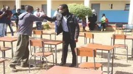  ??  ?? Mzingane Old Boys Associatio­n (Moba) project manager Aaron Chingombe (left) hands over tables and chairs to Mzingwane High School headmaster Mr Maroka Magaya during the ceremony held at the school in UMzingwane District, Matabelela­nd South yesterday