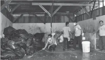  ?? PAUL JUN E. ROSAROSO ?? Workers clean the floor of Vicente Sotto Memorial Medical Center’s garbage storage area after Cebu City Hall’s Department of Public Services, which allegedly did not head repeated reminders from the hospital, finally took out the trash there.