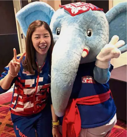  ??  ?? Calm before the storm: Soniia Cheah posing with the Thomas-Uber Cup Finals mascot at the Impact Arena in Bangkok yesterday.