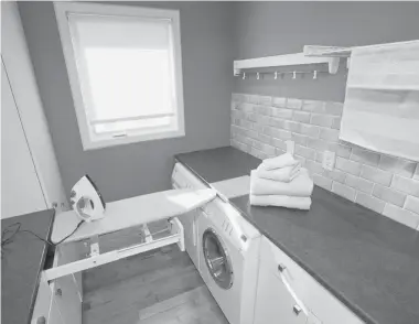  ?? WAYNE CUDDINGTON/Postmedia News ?? Plan carefully and calculate how much space you need, designer Penny Southam says. This home in Ottawa’s west end
features a small but super-efficient laundry room with a pullout ironing board and drop-down drying racks.