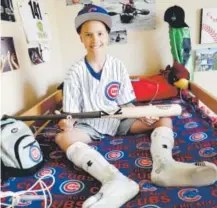  ??  ?? Campbell Faulkner, 10, shows a custom-made baseball bat given to him by the Cubs’ Kyle Schwarber, at his home in Queen Creek, Ariz., on Thursday. Matt York, The Associated Press