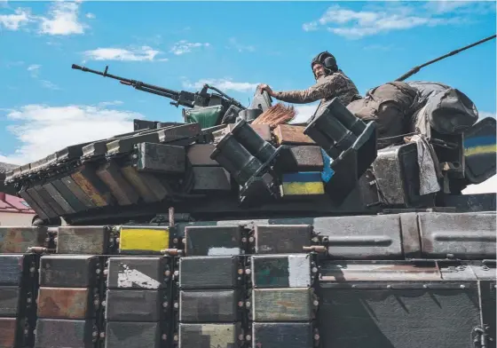  ?? ?? A Ukrainian soldier sits on a tank carried by a transporte­r towards the increasing­ly heavy fighting in eastern Ukraine. Picture: AFP