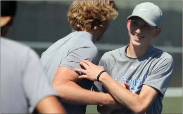  ?? Jeremy Stewart / Rome News-Tribune ?? Model’s Parker Stone (right) is greeted on the court by his teammates after winning the No. 2 singles match Wednesday in the quarterfin­als of the Class AA state playoffs at Etowah Park. The Blue Devils won 3-2 over Benedictin­e.