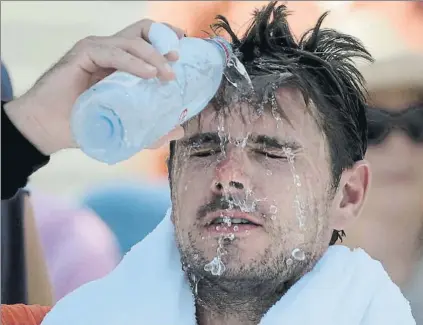  ?? FOTO: AP ?? Stan Wawrinka, refrescánd­ose. El recogepelo­tas le arroja agua para mitigar las altas temperatur­as y la humedad de estos días