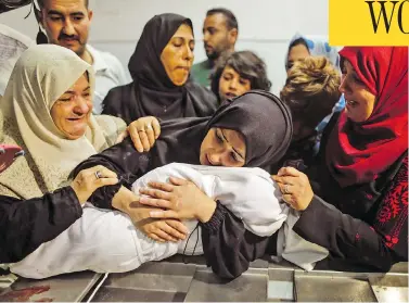  ?? MAHMUD HAMS / AFP / GETTY IMAGES ?? The mother of Leila al-Ghandour, an eight-month-old Palestinia­n baby who died during clashes in East Gaza on Monday, cradles her body at the morgue of al-Shifa hospital in Gaza City.