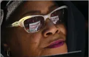  ??  ?? Patricia Cheeks from Philadelph­ia held a sign that’s reflected in her sunglasses. It says, “We Want to Work.”