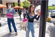  ?? EVAN VUCCI/ASSOCIATED PRESS ?? Students from George Washington University and American University put up posters near the White House calling for student loan debt forgivenes­s on Friday in Washington, D.C.