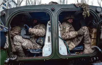  ?? Evgeniy Maloletka/Associated Press ?? Ukrainian marine servicemen sit inside an APC in the city of Vuhledar before going to the front line. Fighting continues in Ukraine after the one-year anniversar­y of Russia’s invasion.