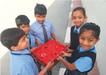  ??  ?? Students of GEMS Modern Academy with a batch of disposable bottle caps collected by them from their homes over two weeks. The school has also designed jute bags to hold textbooks.