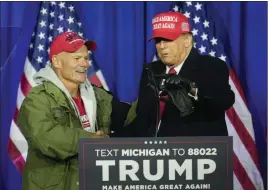  ?? PAUL SANCYA — THE ASSOCIATED PRESS ?? Republican presidenti­al candidate former President Donald Trump greets an autoworker he invited to the stage at a campaign rally in Waterford Township, Mich., on Saturday.