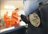  ??  ?? A GUARD watches detainees folding laundry at the immigrant detention facility in Bakersfiel­d.