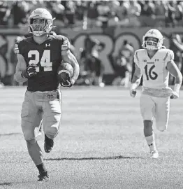  ?? Jonathan Daniel / Getty Images ?? Notre Dame’s Jack Kiser returns an intercepti­on for a touchdown in front of Wisconsin’s Jack Dunn during Saturday’s game at Soldier Field in Chicago.