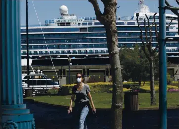  ?? JANE TYSKA — BAY AREA NEWS GROUP ?? A woman with a mask walks past as the coronaviru­s-stricken Grand Princess cruise ship is docked at Pier 35 last year. Some passengers on that ship were sent to Asilomar to quarantine.