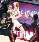  ?? AP photo ?? Donte DiVincenzo of the Bucks looks to pass as the Heat’s Goran Dragic and Bam Adebayo defend during the first half of Milwaukee’s 144-97 rout of Miami on Tuesday.