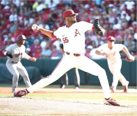  ?? Michael Woods/Associated Press ?? ■ Arkansas pitcher Isaiah Campbell throws a pitch against South Carolina in the first inning of an NCAA college baseball tournament super regional baseball game Monday in Fayettevil­le, Ark. Arkansas defeated South Carolina to secure its spot in the College World Series.