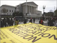  ?? AP PHOTO/AMANDA ANDRADE-RHOADES ?? Abortion rights activists unfurl a banner, created by the ACLU, filled with names of people who said they support the continued access to medication abortion, outside the Supreme Court, on Tuesday in Washington.