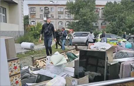  ?? Sergey Bobok AFP/Getty Images ?? IN THE KHARKIV region of eastern Ukraine, residents collect belongings from a building that was badly damaged in a missile strike.