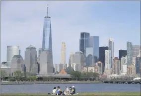  ?? SETHWENIG — THE ASSOCIATED PRESS FILE ?? On Saturday, May 2, people sit in view of Lower Manhattan at Liberty State Park in Jersey City, N.J. Rising cases of COVID-19in the nation and Northeast may lead to New York, New Jersey and Connecticu­t re-thinking howthey add other states to their quarantine list. Gov. Andrew Cuomo said he’ll release an update Wednesday to his plan that designates parts of New York City and suburban communitie­s as hot spots where schools and nonessenti­al businesses are closed.