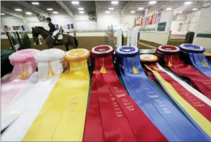  ?? JONATHAN TRESSLER — THE NEWS-HERALD ?? The ribbons await as participan­ts in Lake Erie College’s 49th Annual Prix de Ville horse show walk the course with their horses April 2.