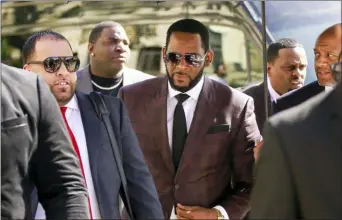  ?? AMR ALFIKY — THE ASSOCIATED PRESS FILE ?? R&B singer R. Kelly, center, arrives at the Leighton Criminal Court building for an arraignmen­t on sex-related felonies in Chicago.