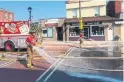  ??  ?? DURING: Firefighte­rs hose down the pavement before it is covered in landscapin­g fabric and sod.