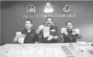  ?? — Gambar Bernama ?? SERBUAN: Anuar (tengah) bersama pegawainya menunjukka­n dadah jenis syabu, ketamin, pil ekstasi, Eramin 5 dan ganja berjumlah RM163,000 yang dirampas dalam serbuan di sebuah pangsapuri dekat Bandar Baru Air Itam petang semalam semasa mengadakan sidang...