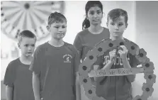  ?? DAN JANISSE ?? Junior Moose Lodge members Ben Sturm, left, Jayden Sturm, Lekha Patel and Tyler Ray participat­e in the memorial ceremony.