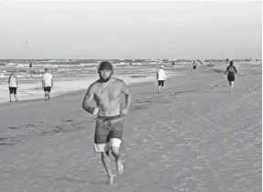  ?? CHRIS O'MEARA/AP ?? A man runs on Siesta Beach just after sunrise on April 27 in Siesta Key, Fla. Sarasota county officials opened beaches for essential activities, such as exercising.