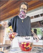  ??  ?? Caroline Barrett scoops out sangria fruit salad at her home in Delmar.