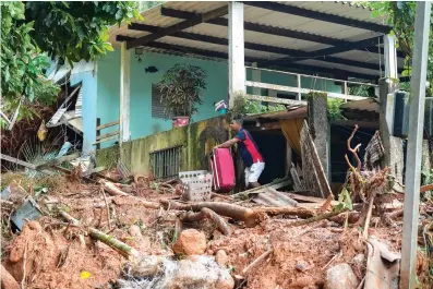  ?? The Associated Press ?? A resident leaves his home with luggage after flooding triggered deadly landslides near Juquehy beach in Sao Sebastiao, Brazil, on Monday.